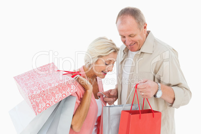 Smiling mature couple holding shopping bags