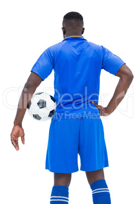 Football player in blue holding ball