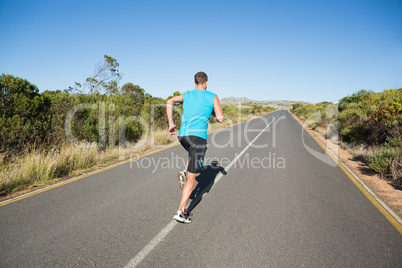 Fit man jogging on the open road