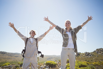 Hiking couple standing on mountain terrain smiling at camera