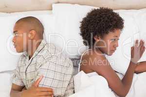 Unhappy couple lying on bed not talking