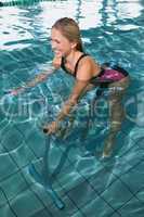 Fit happy blonde using underwater exercise bike