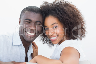 Couple sitting on couch together smiling at camera