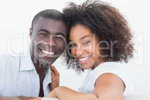 Couple sitting on couch together smiling at camera