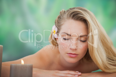 Peaceful blonde lying on towel with candle