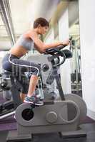 Fit brunette working out on the exercise bike