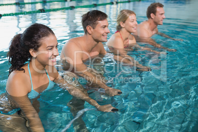 Fitness class doing aqua aerobics on exercise bikes