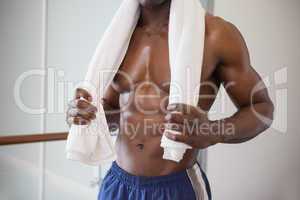 Muscular man holding towel around neck