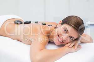 Beautiful woman receiving stone massage at spa center