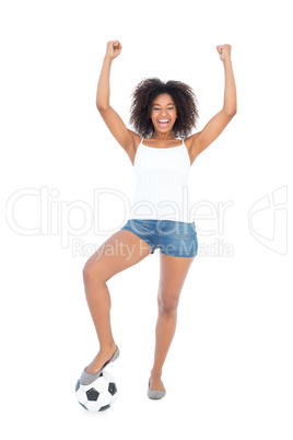 Pretty girl in white top and denim hot pants with football