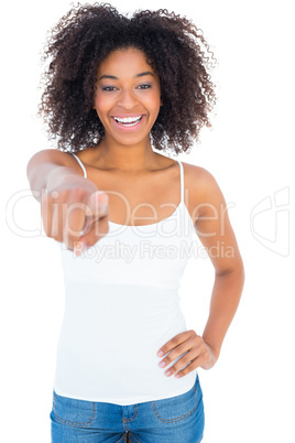 Pretty girl in white top and denim hot pants pointing at camera