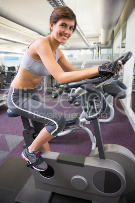 Fit smiling woman working out on the exercise bike