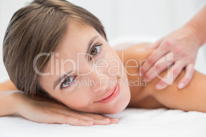 Attractive woman receiving shoulder massage at spa center