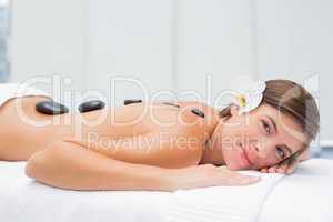 Beautiful woman receiving stone massage at spa center