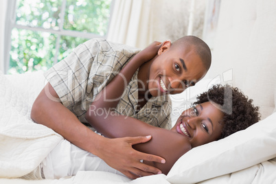 Intimate couple cuddling lying on their bed