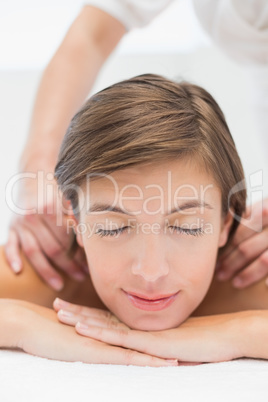 Attractive woman receiving shoulder massage at spa center