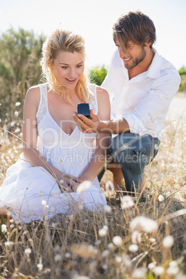 Attractive man proposing to his girlfriend in the country