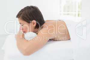 Beautiful woman lying on massage table at spa center