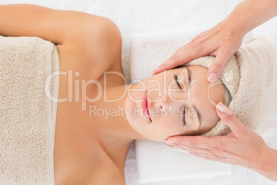 Attractive woman receiving facial massage at spa center