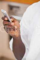 Man in bathrobe holding smartphone