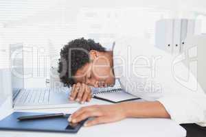 Exhausted businessman sleeping at his desk