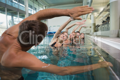 Female fitness class doing aqua aerobics with male instructor