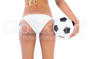 Fit girl in white bikini holding football