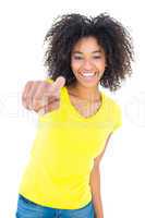 Pretty girl in yellow tshirt and denim hot pants smiling at came