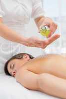 Woman getting massage oil on her back at spa center