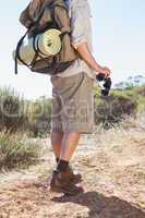 Hiker holding his binoculars on country trail