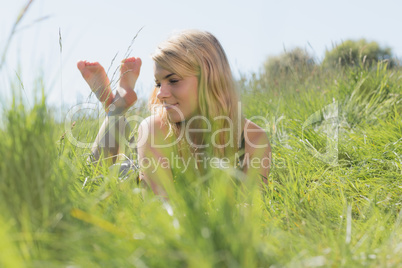 Pretty blonde in sundress lying on grass