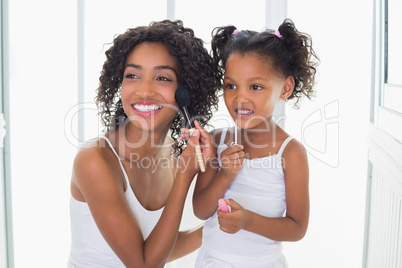 Pretty mother teaching her daughter about makeup