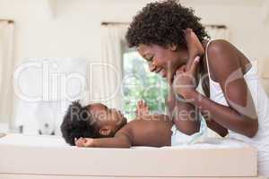 Happy mother with baby girl on changing table