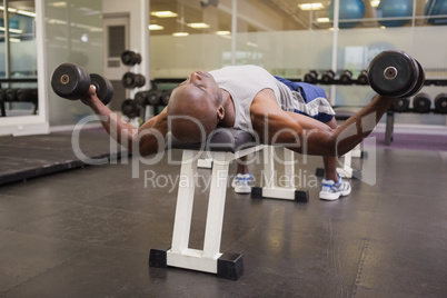 Muscular man exercising with dumbbells