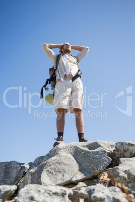 Handsome hiker standing at the summit