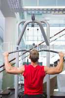 Strong man using weights machine for arms