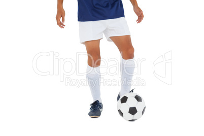 Football player in blue kicking ball