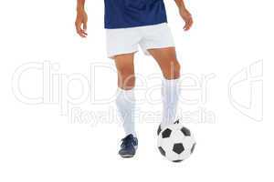 Football player in blue kicking ball