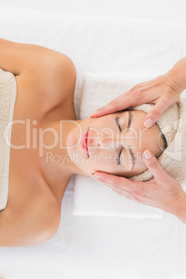 Attractive woman receiving facial massage at spa center