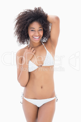 Athletic girl in white bikini smiling at camera