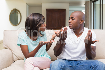 Unhappy couple having an argument on the couch