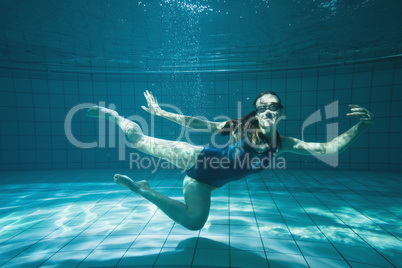 Athletic swimmer smiling at camera underwater