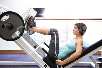 Fit brunette using weights machine for legs