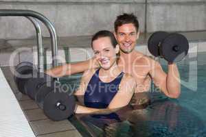 Happy couple working out with foam dumbbells