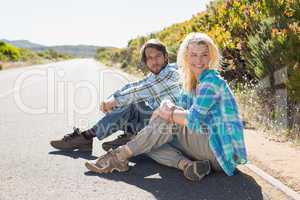 Attractive couple sitting on the road
