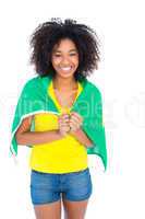 Pretty girl in yellow tshirt and brazilian flag smiling at camer