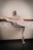 Beautiful ballerina warming up with the barre