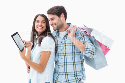 Attractive young couple with shopping bags and tablet pc