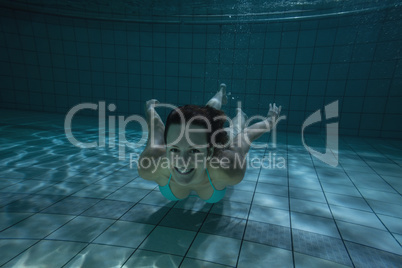 Pretty brunette smiling at camera underwater