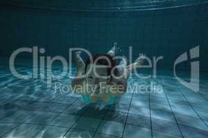 Pretty brunette smiling at camera underwater